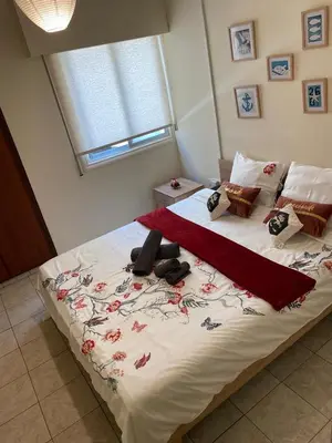 a bedroom with a large white bed with flowers on it at City Comfortable Apartment in Larnaka