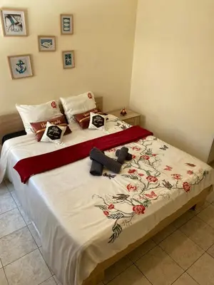 a bedroom with a large bed with a floral bedspread at City Comfortable Apartment in Larnaka