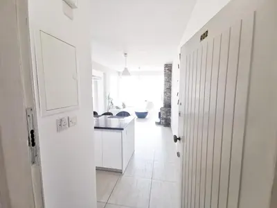 a hallway with a white kitchen and a white door at Mackenzie Seaview Paradise in Larnaka
