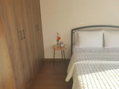 a bedroom with a bed and a wooden cabinet at Melissonas Villas in Phini