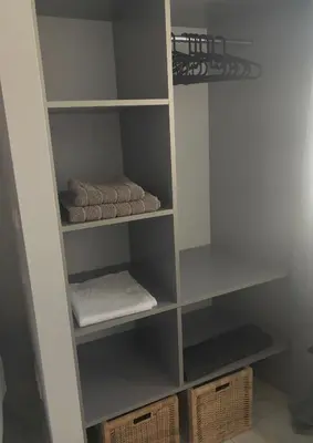 a closet with white shelves and folded towels at Angel Suites in Nicosia