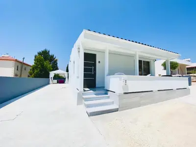 a white house with a bath tub on a sidewalk at SANDY BAY Villa in Ayia Napa