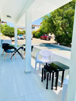 a patio with a table and chairs on it at SANDY BAY Villa in Ayia Napa