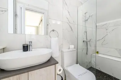 a white bathroom with a sink and a toilet at Olivine Waves in Protaras