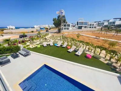 an aerial view of a resort with a swimming pool and chairs at Olivine Waves in Protaras
