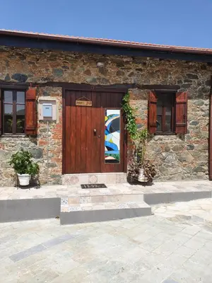 a stone house with a wooden door and windows at Petradaki House in Arakapas