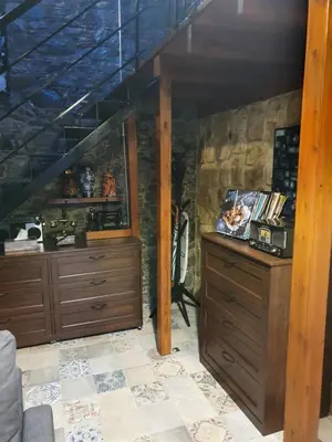 a room with two wooden dressers and a staircase at Petradaki House in Arakapas