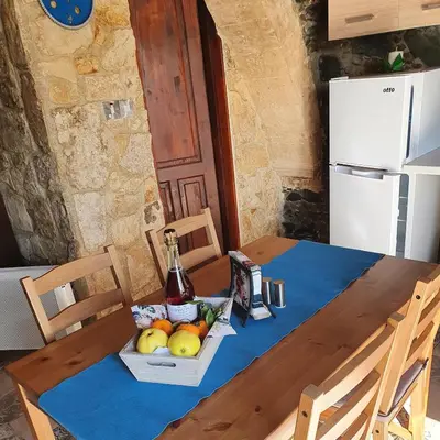 a table with a bowl of fruit and a bottle of wine at Petradaki House in Arakapas