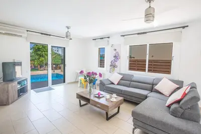 a living room with a couch and a tv at Ariella Villa in Protaras