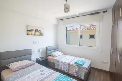 a bedroom with two beds and a window at Ariella Villa in Protaras
