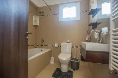 a bathroom with a toilet and a tub and a sink at Ariella Villa in Protaras