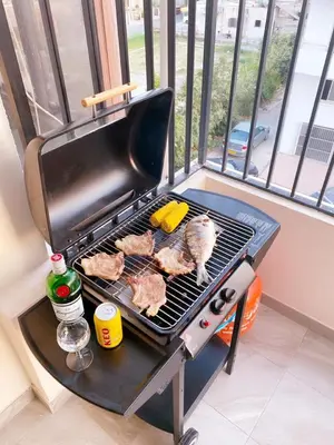 a chicken standing on a grill on a balcony at City Comfort Rooms in Larnaka
