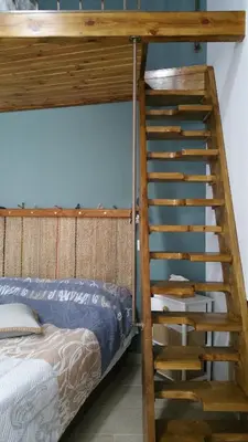 a wooden bunk bed with a ladder next to a bed at Magdalene's City House Inn in Larnaka