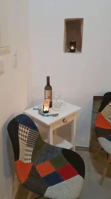 a table with a bottle of wine and two chairs at Magdalene's City House Inn in Larnaka