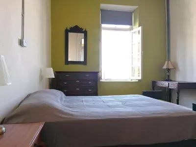 a bedroom with a bed and a window and a dresser at Le Mat Hostel in Larnaka