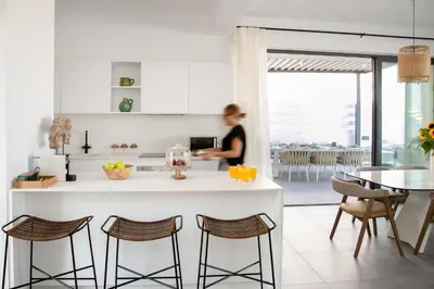 a woman in a kitchen with a counter and chairs at Chris Le Mare Gold Luxury Villa in Protaras