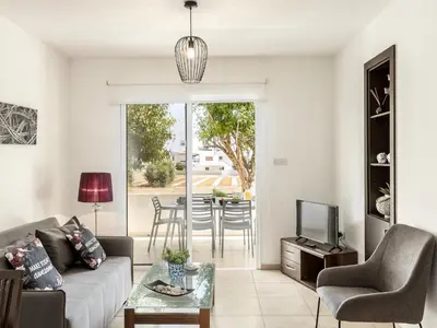 a living room with a couch and a tv at Mythical Sands Resort in Protaras