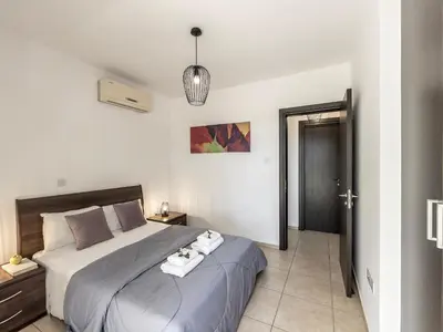a bedroom with a large bed with towels on it at Mythical Sands Resort in Protaras