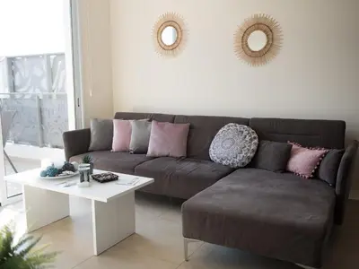 a living room with a brown couch and a white table at Mythical Sands Resort in Protaras