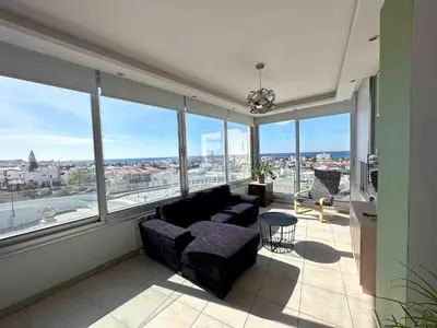a living room with a couch and large windows at Topikos Apartments in Ayia Napa