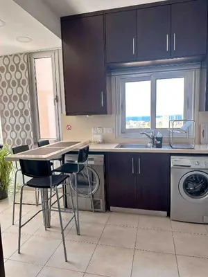 a kitchen with a table and chairs and a sink at Topikos Apartments in Ayia Napa
