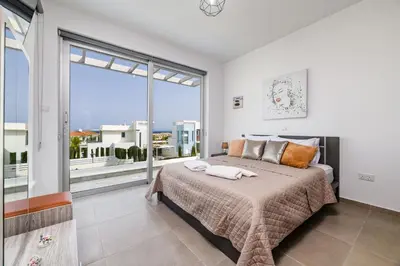 a bedroom with a large bed and a large window at Mylos Lifestyle Seaview Villa #21 in Protaras