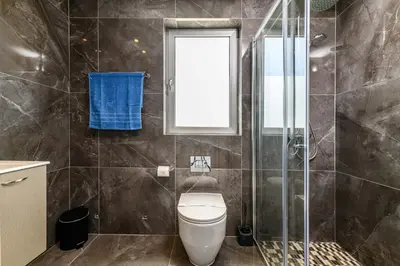 a bathroom with a toilet and a glass shower at Mylos Lifestyle Seaview Villa #21 in Protaras