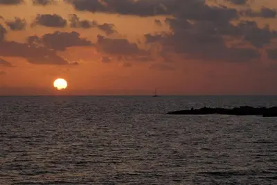 a sunset over the ocean with a boat in the distance at Apt Misia Enas - Modern 2 Bedroom Apartment With Sea Views - Close To Ayia Napa in Ayia Napa