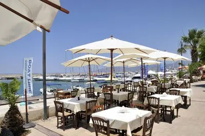 a restaurant with white tables and umbrellas at Apt Misia Enas - Modern 2 Bedroom Apartment With Sea Views - Close To Ayia Napa in Ayia Napa