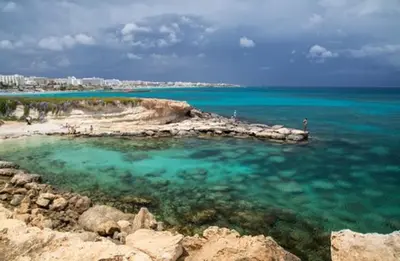 a beach with blue water and a city in the background at Apt Misia Enas - Modern 2 Bedroom Apartment With Sea Views - Close To Ayia Napa in Ayia Napa
