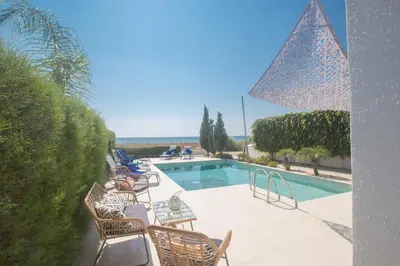 a swimming pool with a bunch of chairs around it at Sunrise Villa 12 in Ayia Napa
