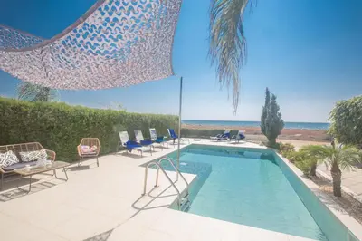 a swimming pool with chairs and a view of the ocean at Sunrise Villa 12 in Ayia Napa