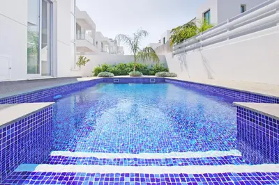 a swimming pool in a house with blue tiles at Villa Greta in Protaras