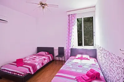 two beds in a room with pink and purple at Villa Mavris - Lovely 4 Bedroom Villa With Private Pool In Central Ayia Napa in Ayia Napa