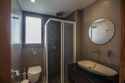 a bathroom with a sink and a toilet and a mirror at Villa Petreris Dyo - Lovely 3 Bedroom Central Ayia Napa Villa With Pool in Ayia Napa