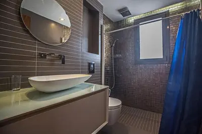 a bathroom with a sink and a toilet and a mirror at Villa Petreris Dyo - Lovely 3 Bedroom Central Ayia Napa Villa With Pool in Ayia Napa