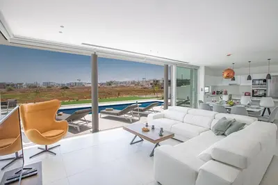a living room with white furniture and a large window at Villa Manta Agrotikos - Stunning 3 Bedroom Protaras Villa With Pool in Protaras