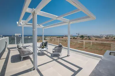 a patio with two chairs and a table on a balcony at Villa Manta Agrotikos - Stunning 3 Bedroom Protaras Villa With Pool in Protaras