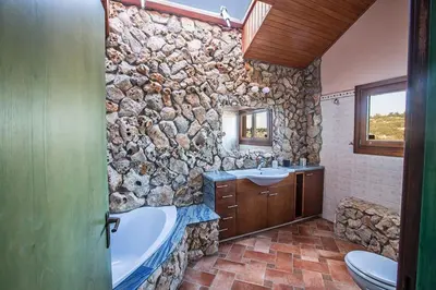 a stone walled bathroom with a tub and a sink at Villa Ayia Napa Foothills, Exquisite 5Bdr Ayia Napa Villa With Pool in Ayia Napa