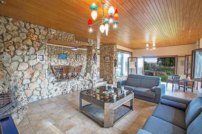 a living room with a stone wall at Villa Ayia Napa Foothills, Exquisite 5Bdr Ayia Napa Villa With Pool in Ayia Napa