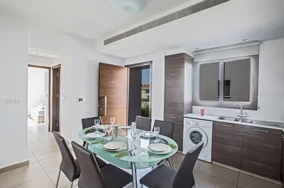 a dining room with a table and chairs in a kitchen at Villa Petreris Enas - Stunning 3 Bedroom Central Ayia Napa Villa With Pool in Ayia Napa