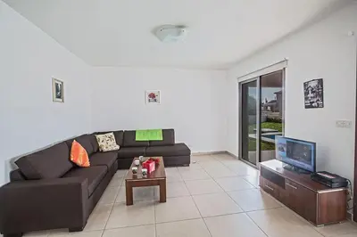 a living room with a couch and a tv at Villa Petreris Enas - Stunning 3 Bedroom Central Ayia Napa Villa With Pool in Ayia Napa