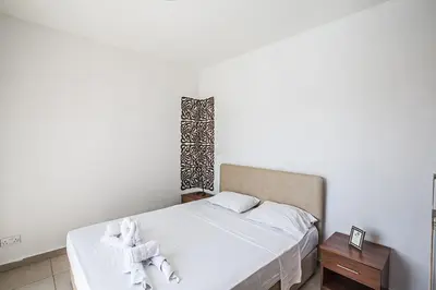 a bedroom with a white bed with towels on it at Villa Petreris Enas - Stunning 3 Bedroom Central Ayia Napa Villa With Pool in Ayia Napa
