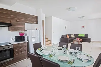 a kitchen and a dining room with a table and chairs at Villa Petreris Enas - Stunning 3 Bedroom Central Ayia Napa Villa With Pool in Ayia Napa