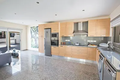 a kitchen with wooden cabinets and stainless steel appliances at Villa Dafnis Platina - Lovely 4 Bedroom Protaras Villa With Private Pool in Protaras