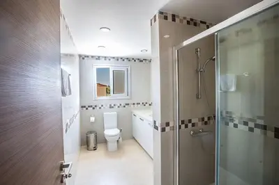 a bathroom with a toilet and a glass shower at Villa Dafnis Platina - Lovely 4 Bedroom Protaras Villa With Private Pool in Protaras