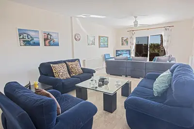 a living room with blue couches and a table at Villa Magusta - Modern 4 Bedroom Ayia Thekla Villa With Pool in Ayia Napa