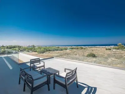a patio with a table and chairs on a roof at Villa Ioanni Chrysos - Luxury And New 6 Bedroom Protaras Villa in Protaras