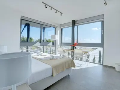 a white bedroom with a bed and a table and chairs at Villa Limni Dyo - Luxurious Contemporary 3 Bedroom Villa With Sea Views And Hot in Paralimni