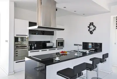 a kitchen with a black counter and black stools at Villa Saranta Gold - Exquisite 3 Bedroom Protaras Villa With Private Pool in Protaras